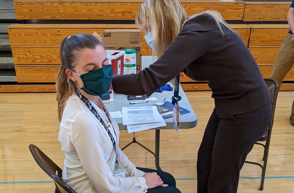 Debbie Millar, RN, vaccinates a local school employee at Cranbury School in central New Jersey.